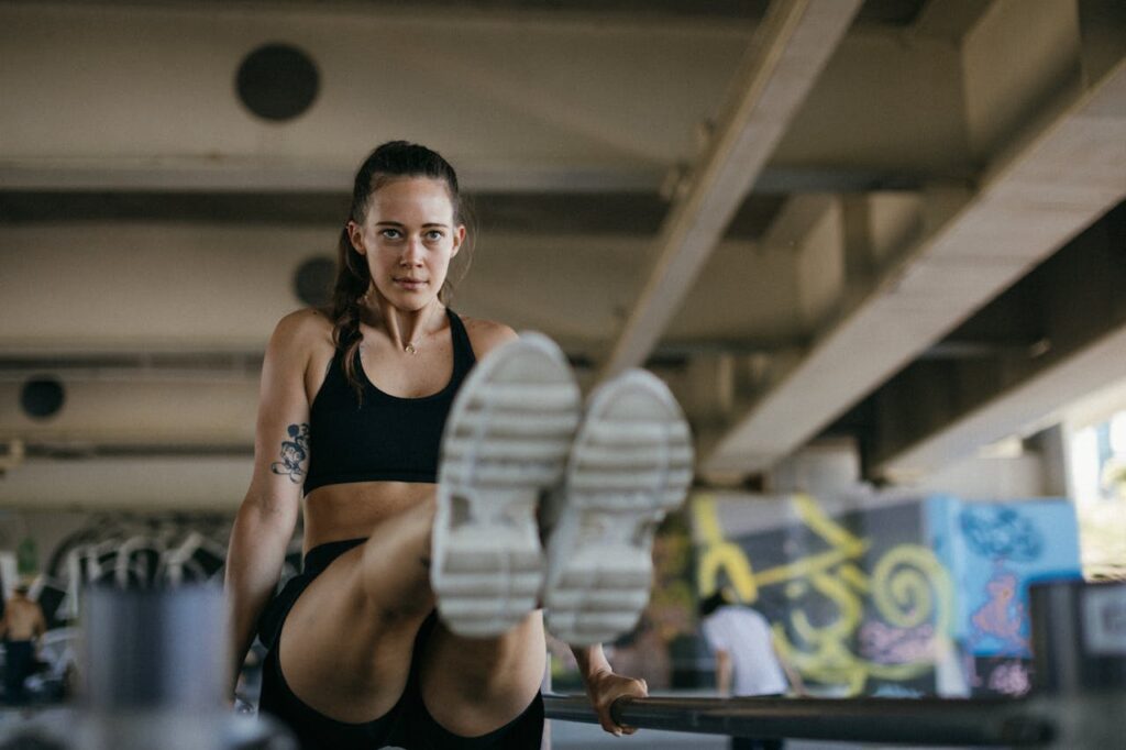 Woman exercising in gym wearing sports bra and shorts, focused and determined.